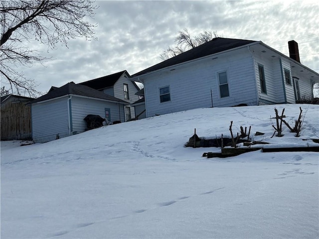 view of snow covered back of property