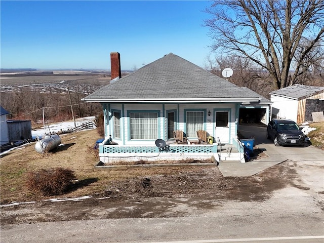 back of house with a garage and covered porch