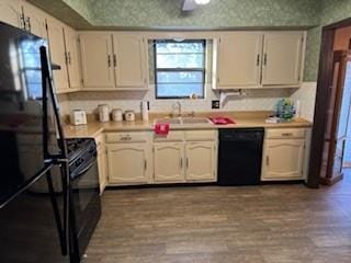 kitchen featuring white cabinetry, sink, light hardwood / wood-style floors, and black appliances