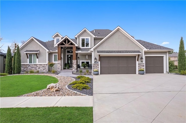 craftsman-style house featuring driveway, stone siding, a front yard, and stucco siding