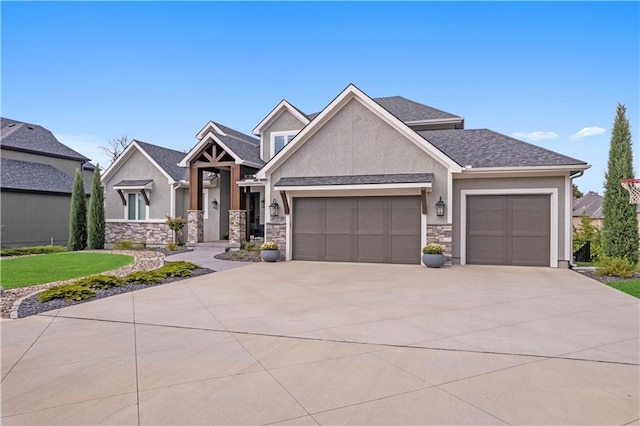 view of front of house with an attached garage, a shingled roof, driveway, stone siding, and stucco siding