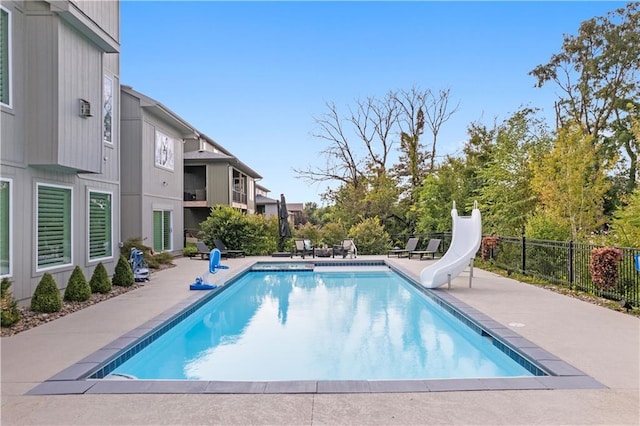 view of swimming pool featuring a water slide, a patio area, fence, and a fenced in pool