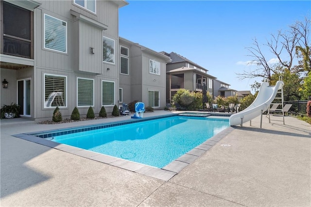 view of pool with a fenced in pool, a water slide, and a patio area