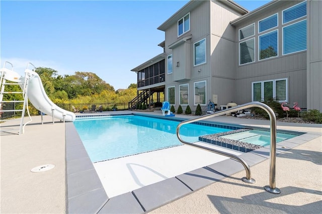 view of pool featuring a water slide, fence, a sunroom, stairs, and a patio area