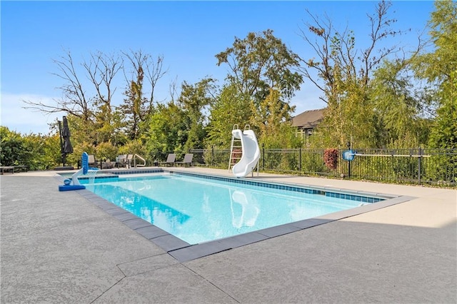 view of swimming pool featuring a water slide, a patio area, fence, and a fenced in pool