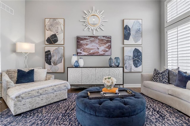 living room with wood finished floors, visible vents, and baseboards