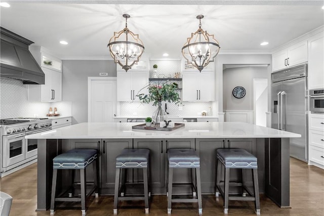 kitchen featuring white cabinets, a large island, a chandelier, and high end appliances