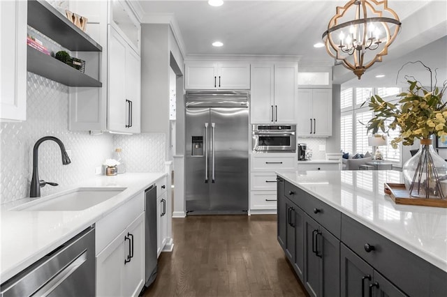 kitchen with stainless steel appliances, light countertops, white cabinets, and a sink