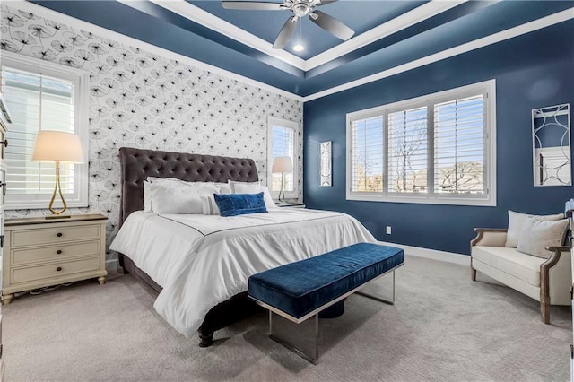 bedroom featuring a raised ceiling, light colored carpet, baseboards, and wallpapered walls