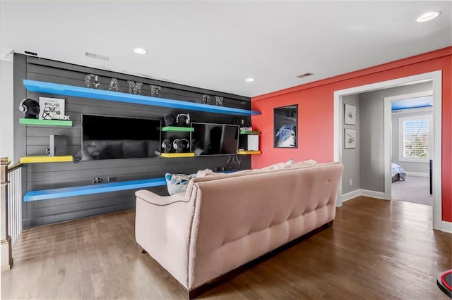 living area with recessed lighting, visible vents, baseboards, and wood finished floors