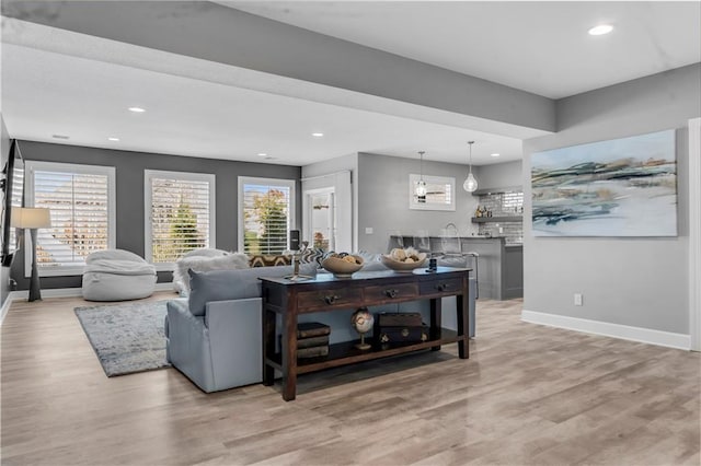 living room featuring light wood finished floors, recessed lighting, and baseboards