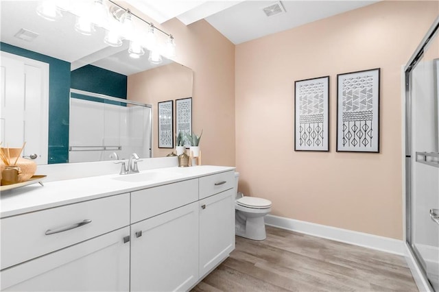 full bathroom with a shower with shower door, wood finished floors, and visible vents