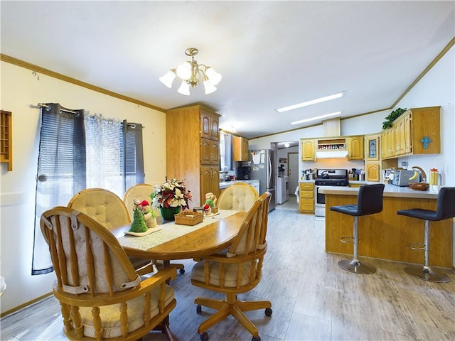 dining space with vaulted ceiling, light hardwood / wood-style flooring, ornamental molding, and an inviting chandelier