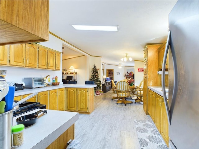 kitchen with ceiling fan, kitchen peninsula, stainless steel fridge, and light hardwood / wood-style flooring