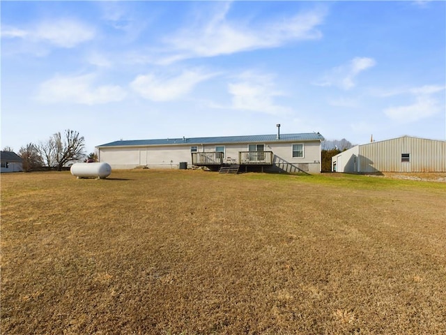 rear view of house featuring a wooden deck and a lawn