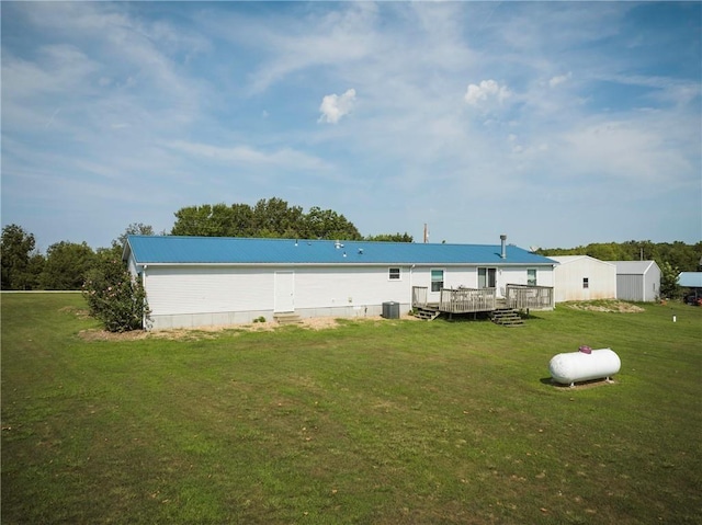 back of property featuring a deck and a lawn