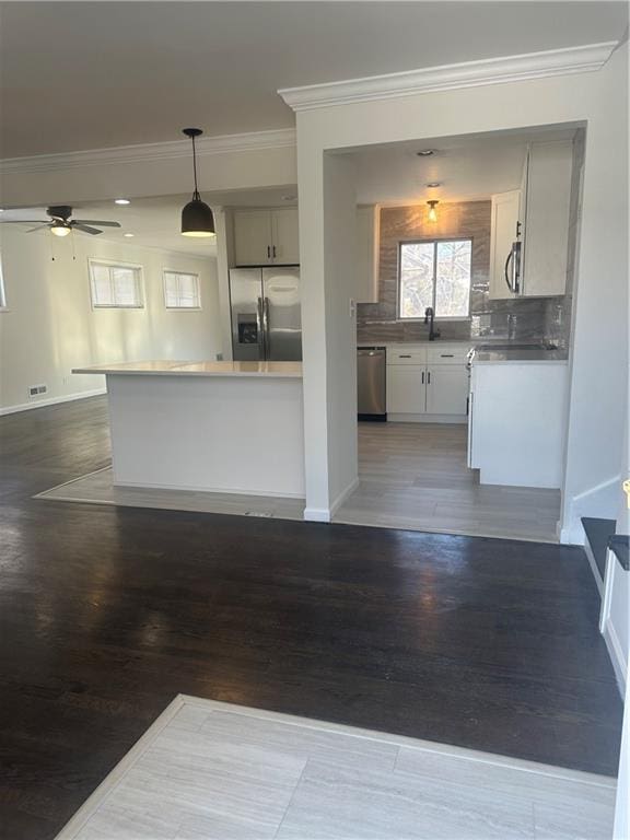 kitchen with ceiling fan, pendant lighting, backsplash, stainless steel appliances, and dark hardwood / wood-style floors