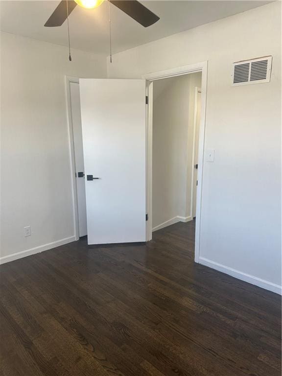 empty room featuring ceiling fan and dark hardwood / wood-style flooring