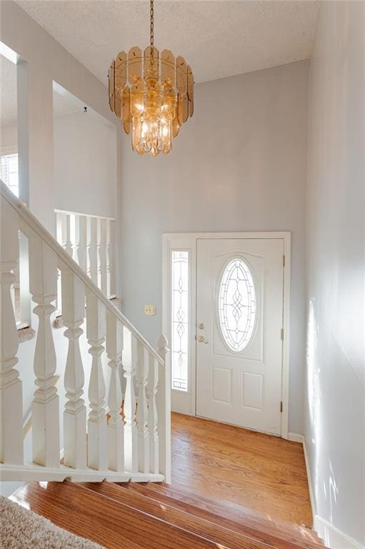 foyer entrance featuring hardwood / wood-style flooring and a notable chandelier