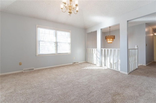 unfurnished room with carpet floors, a chandelier, and a textured ceiling