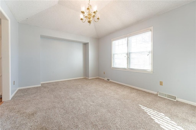 unfurnished room with a textured ceiling, carpet, lofted ceiling, and an inviting chandelier