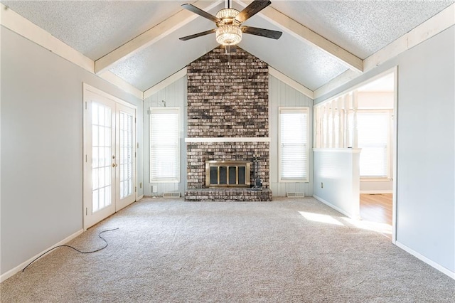 unfurnished living room featuring ceiling fan, light carpet, a brick fireplace, and a textured ceiling