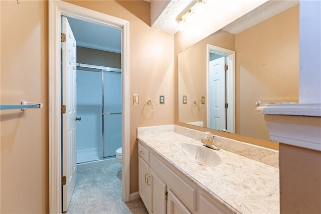 bathroom with an enclosed shower, vanity, and toilet