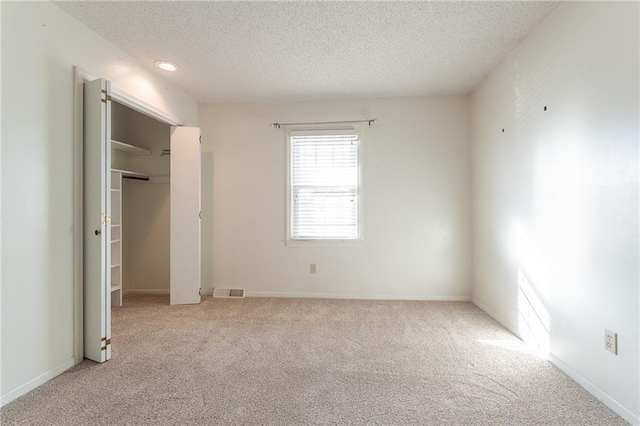 unfurnished bedroom featuring light colored carpet and a textured ceiling