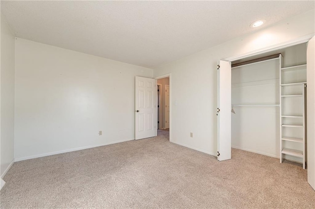 unfurnished bedroom featuring light colored carpet and a closet