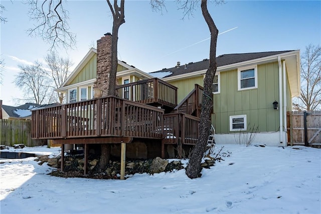 snow covered house featuring a deck