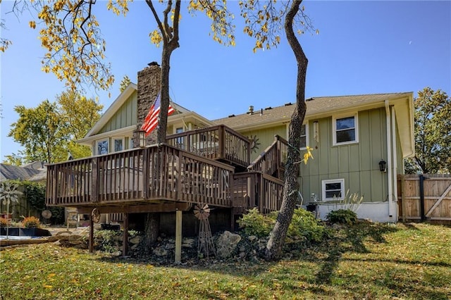 rear view of property featuring a deck and a yard