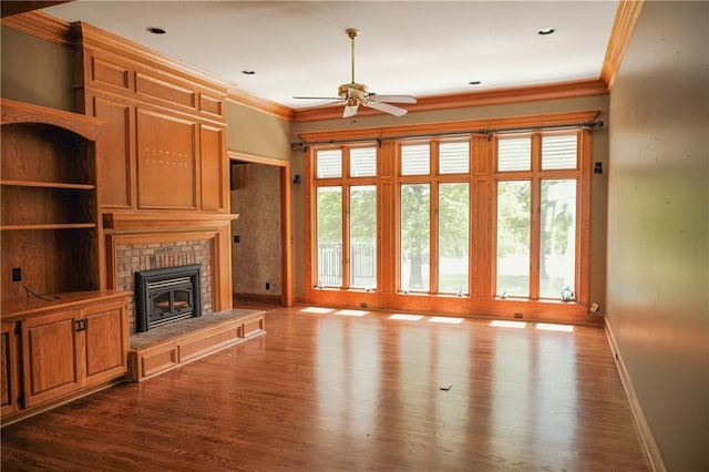 unfurnished living room with baseboards, dark wood-style flooring, ornamental molding, and ceiling fan