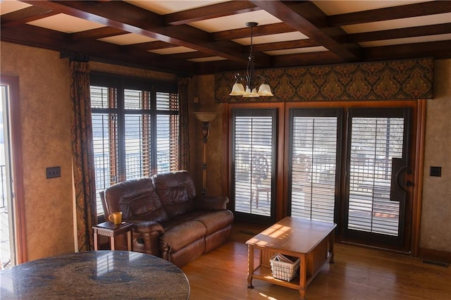 living area featuring beam ceiling, visible vents, coffered ceiling, and wood finished floors