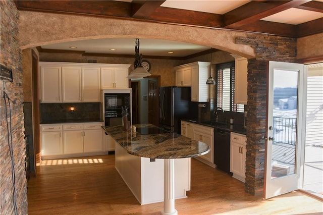 kitchen with a sink, light wood-type flooring, black appliances, white cabinetry, and arched walkways