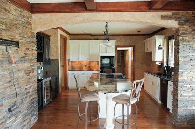 kitchen with crown molding, a kitchen island, dark wood-style flooring, and a sink