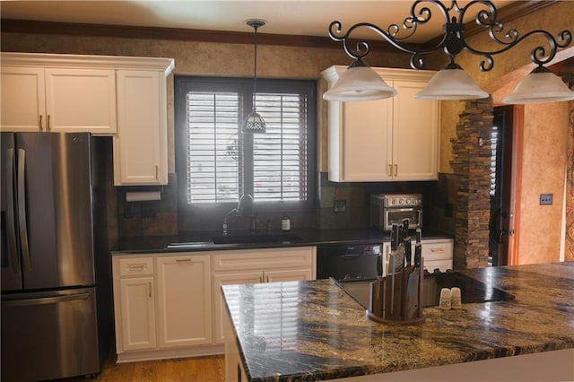kitchen with backsplash, stainless steel fridge, white cabinetry, and a sink