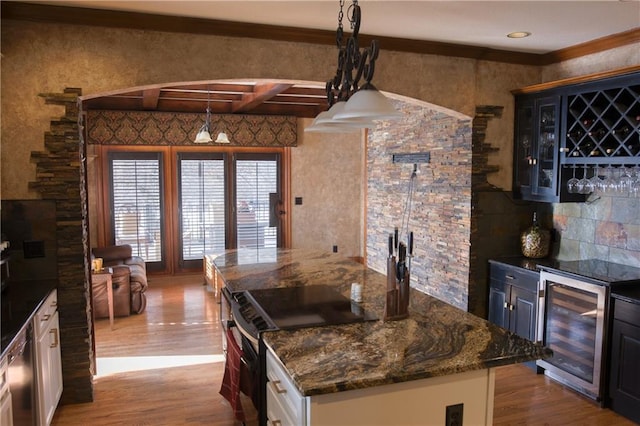 kitchen with wine cooler, a kitchen island, beamed ceiling, wood finished floors, and stainless steel range with electric stovetop