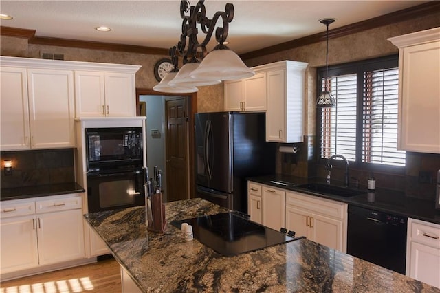 kitchen with black appliances, ornamental molding, white cabinets, and a sink