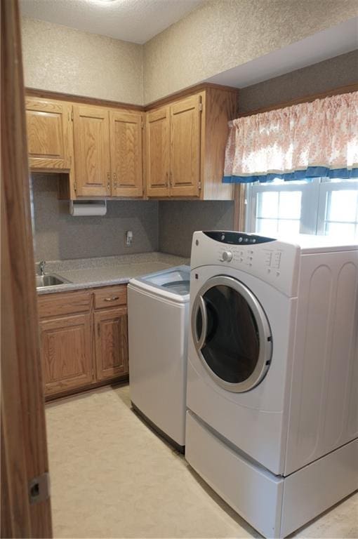 laundry room featuring a sink, independent washer and dryer, and cabinet space