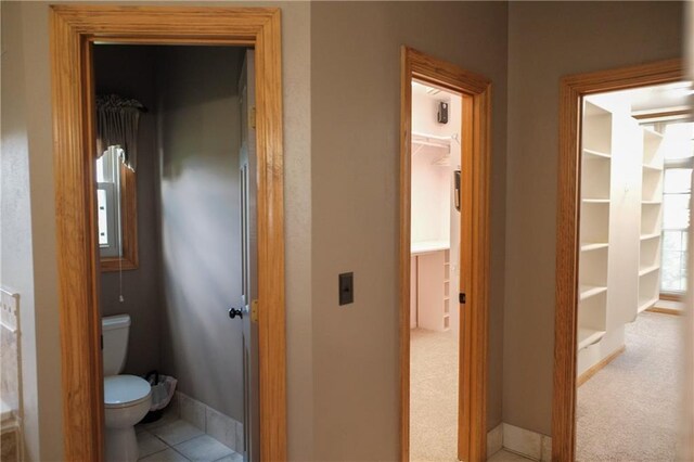 hallway with carpet flooring and baseboards