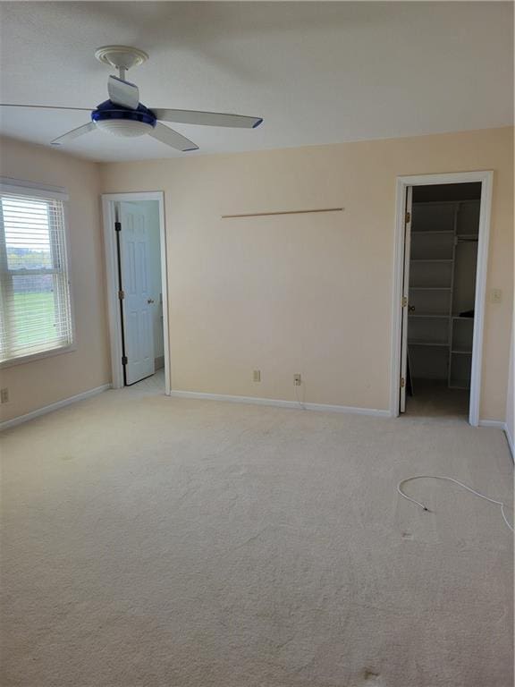 unfurnished bedroom featuring baseboards, ceiling fan, and light colored carpet
