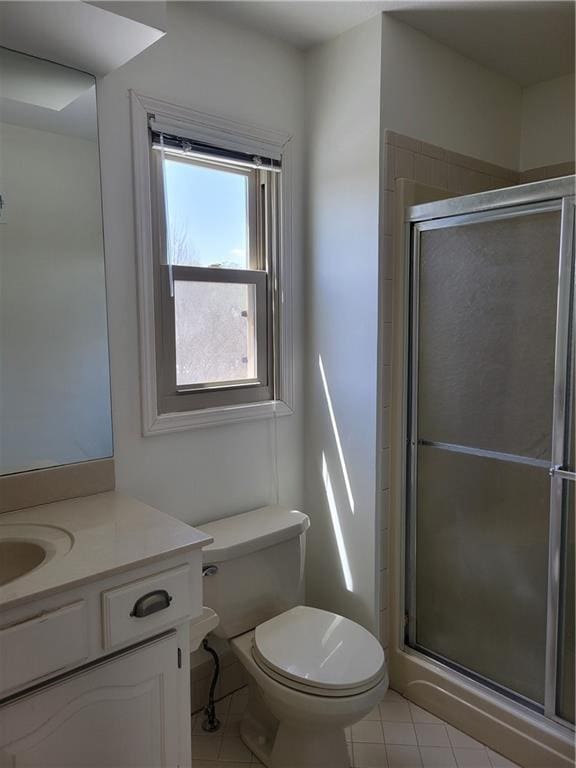 bathroom featuring toilet, a shower stall, and tile patterned floors