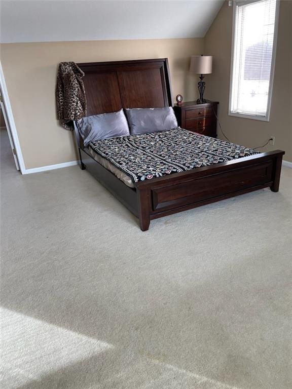 bedroom with baseboards, lofted ceiling, and carpet floors