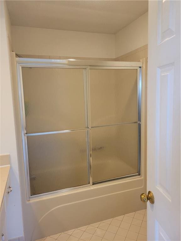full bathroom featuring vanity, bath / shower combo with glass door, and tile patterned flooring