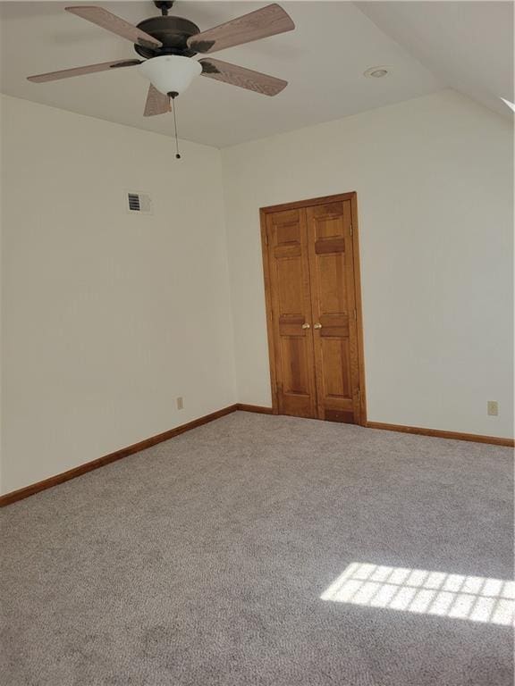 unfurnished room featuring carpet, visible vents, baseboards, and a ceiling fan
