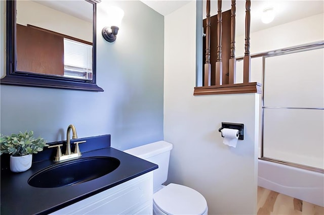 full bathroom with toilet, enclosed tub / shower combo, vanity, and hardwood / wood-style floors