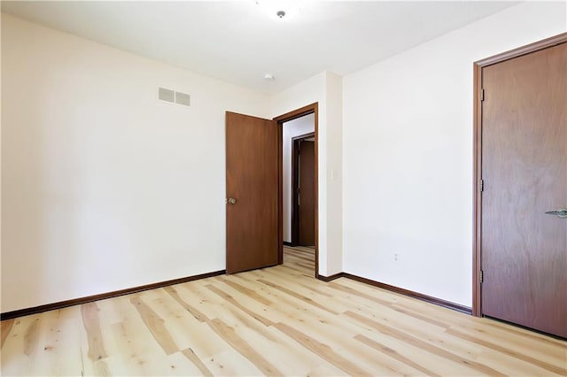 unfurnished bedroom featuring light wood-type flooring and a closet