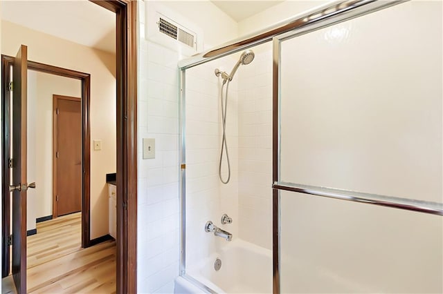 bathroom featuring combined bath / shower with glass door and hardwood / wood-style floors