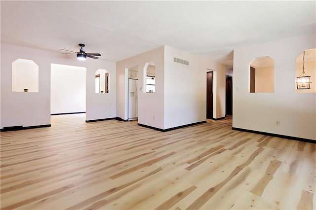 empty room with ceiling fan and light hardwood / wood-style flooring