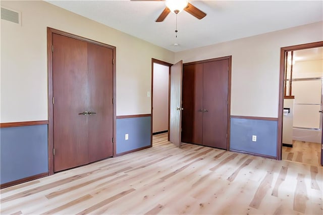 unfurnished bedroom with light wood-type flooring, ceiling fan, and ensuite bath